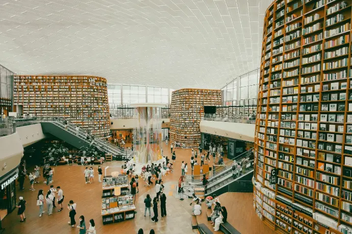 Modern university campus hall with students walking and studying.